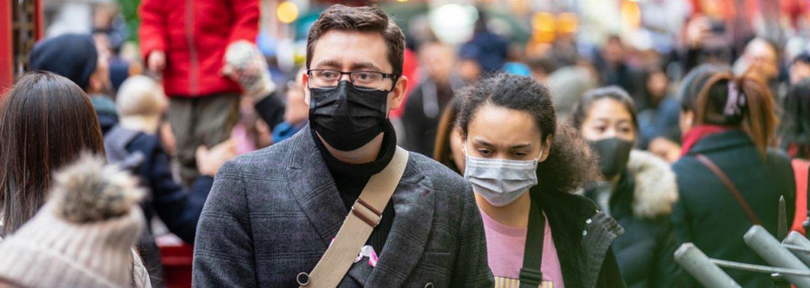 people wearing face masks in a crowded street